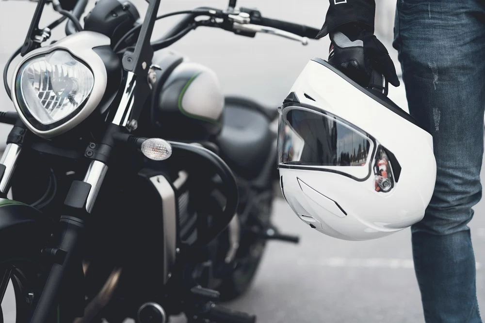 Injured motorcyclist on the road beside a wrecked motorcycle