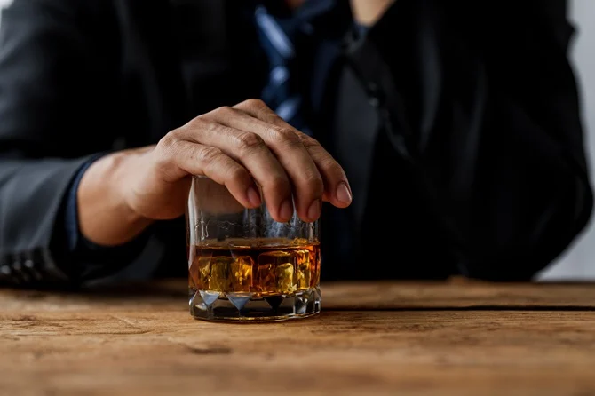 Hand holding a glass of whiskey