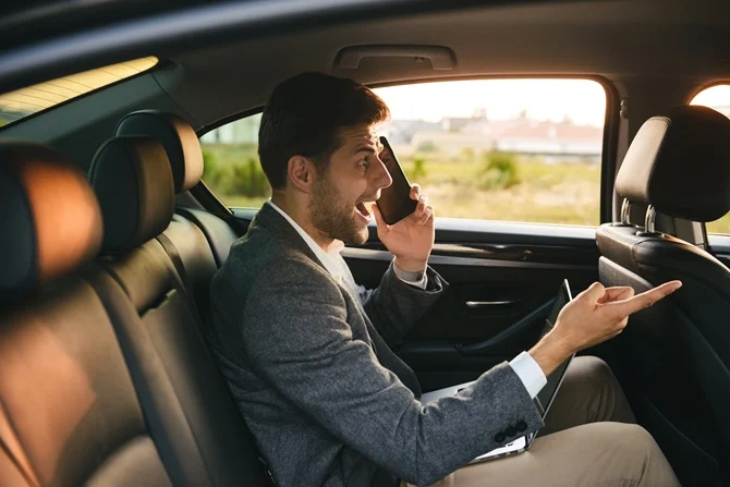 Passenger on the phone in the back seat of a car