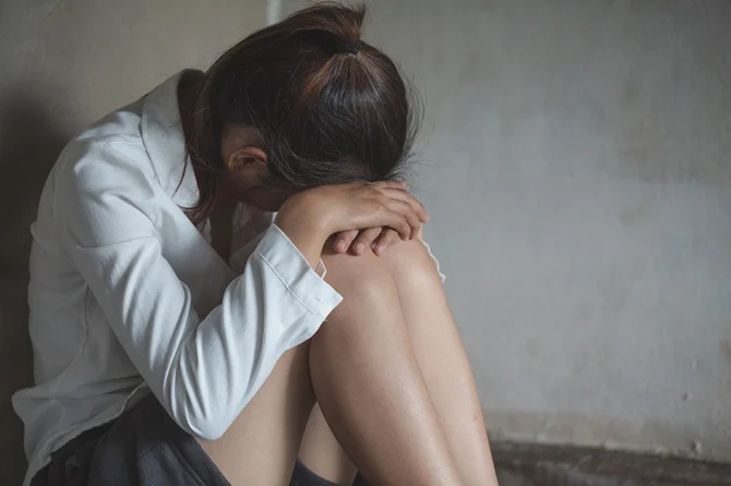 Distressed woman sitting with her head on her knees