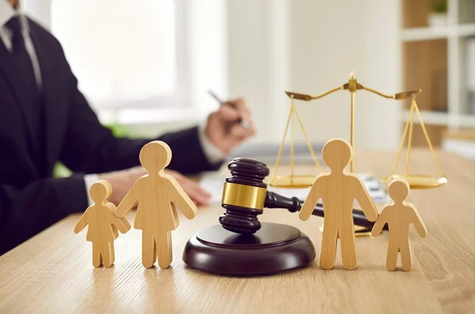 Gavel, scales of justice and wooden family figures