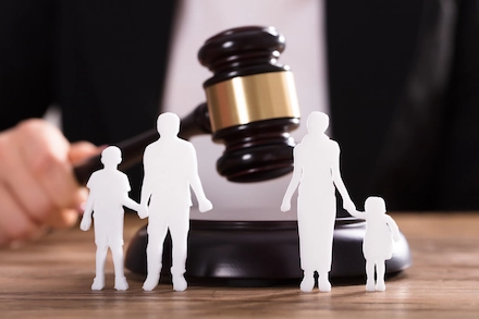 Gavel beside paper cut-outs of a family