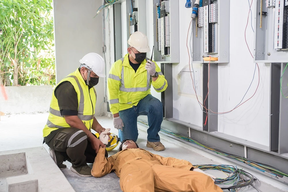Workers helping an electrocuted colleague on the floor