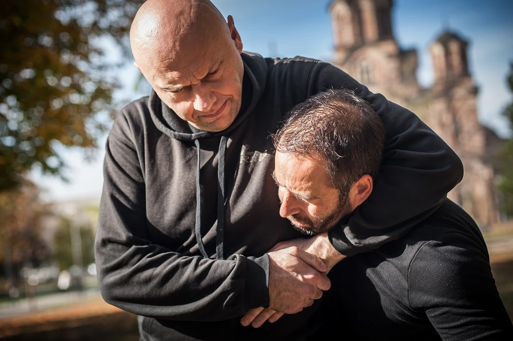 Man grabbing another man in a headlock
